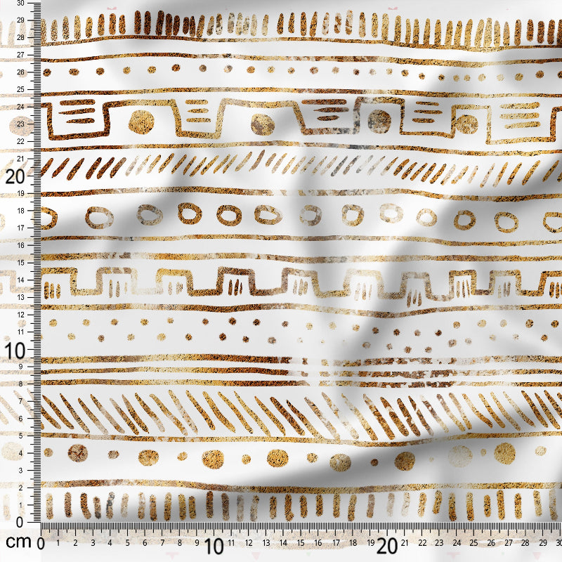 Gold geometric pattern on white fabric with a ruler for scale