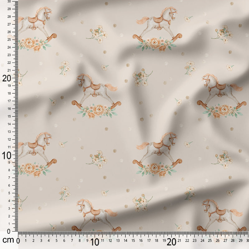 Fabric with rocking horse and floral pattern on a beige background, measured with a ruler.