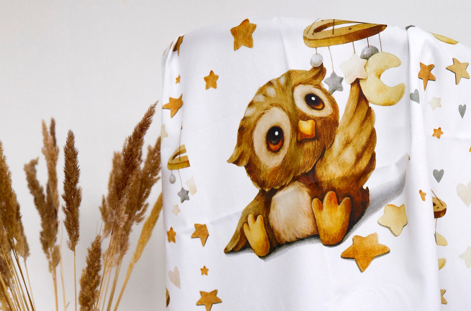 Cotton fabric with a print of cute brown owl holding a star