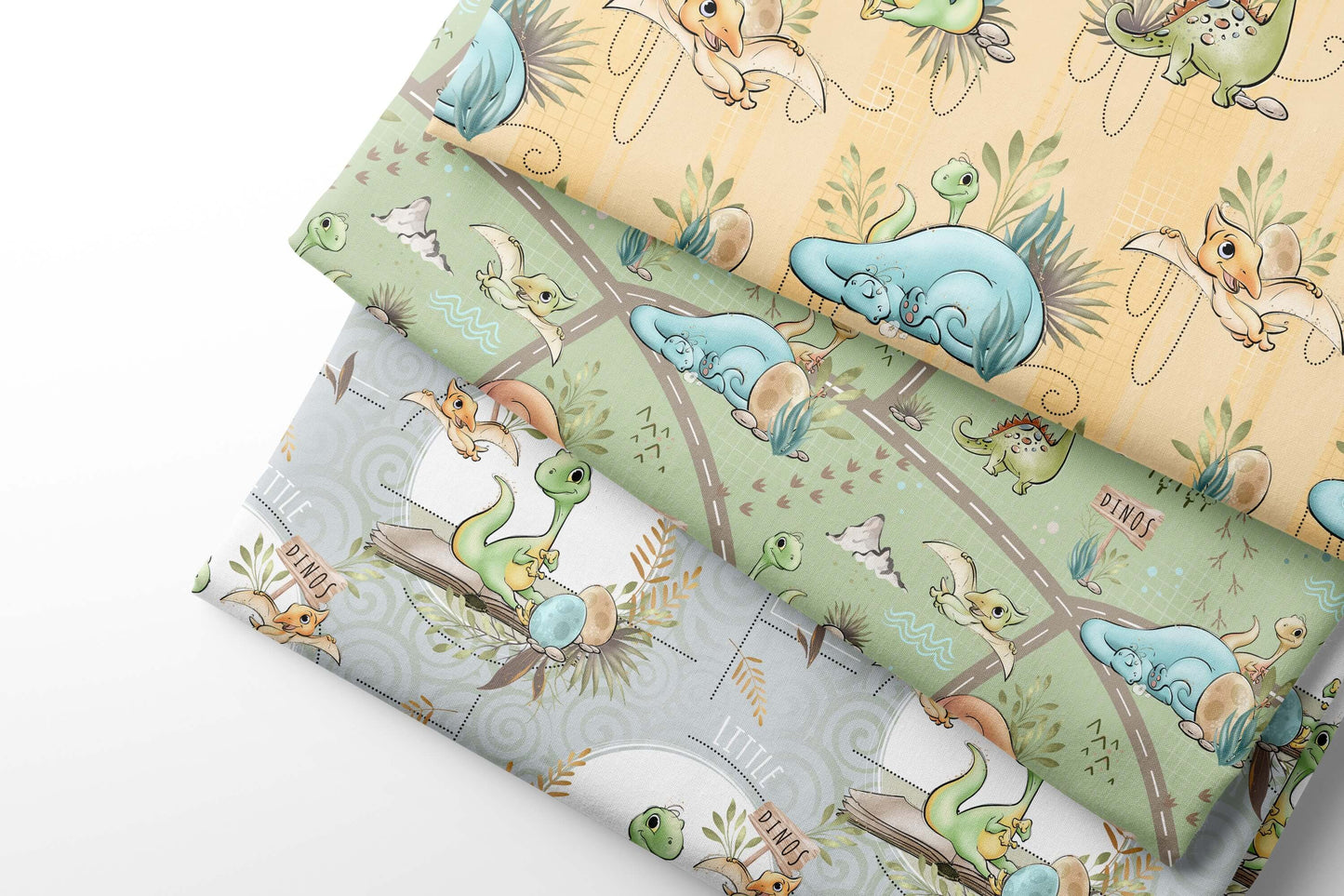 Set of fabric sheets with cartoon dino designs on a light green, yellow and gray background
