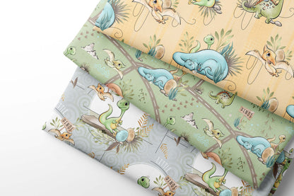 Set of fabric sheets with cartoon dino designs on a light green, yellow and gray background