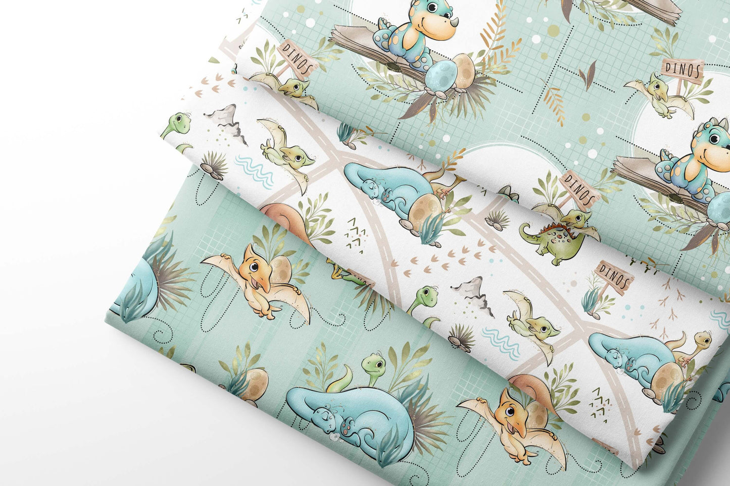 Set of fabric swatches with cartoon dino designs on a light blue, green background