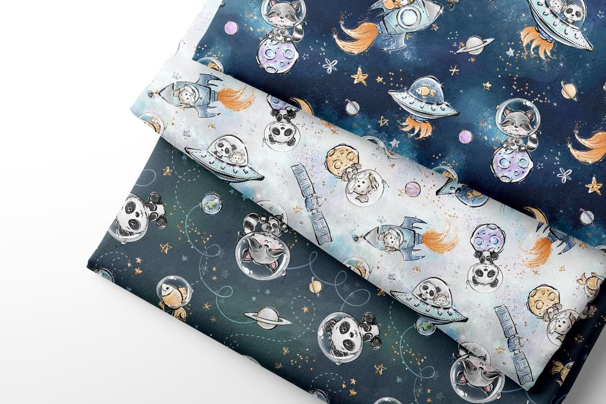 Three rolls of coordinating fabric with space-themed designs featuring astronauts, planets, and stars.
