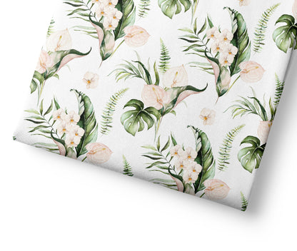 Tropical floral patterned fabric with green leaves and white flowers on a white background