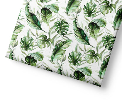 Sheet of fabric with green leaf pattern on a white background