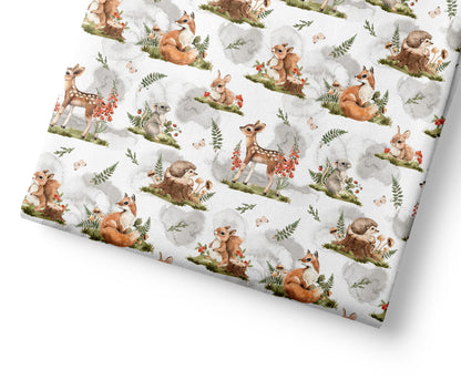 Woodland animal patterned fabric with deer, rabbits, and hedgehogs on a white background