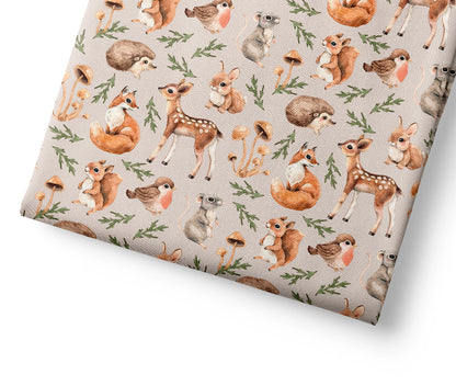 Woodland animal patterned fabric on a light pink background
