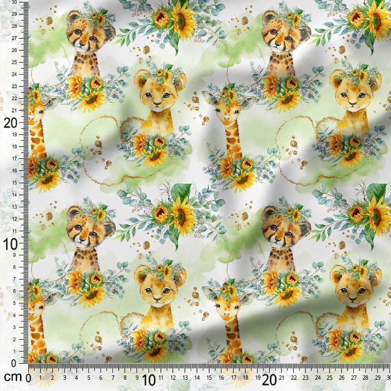 Fabric with lion cubs, giraffes, and flowers on a white background with a ruler for scale.