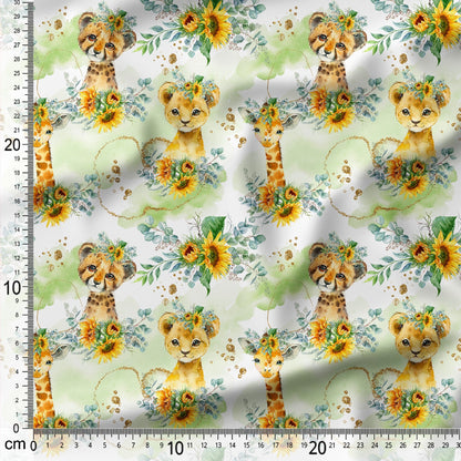 Fabric with lion cubs, giraffes, and flowers on a white background with a ruler for scale.