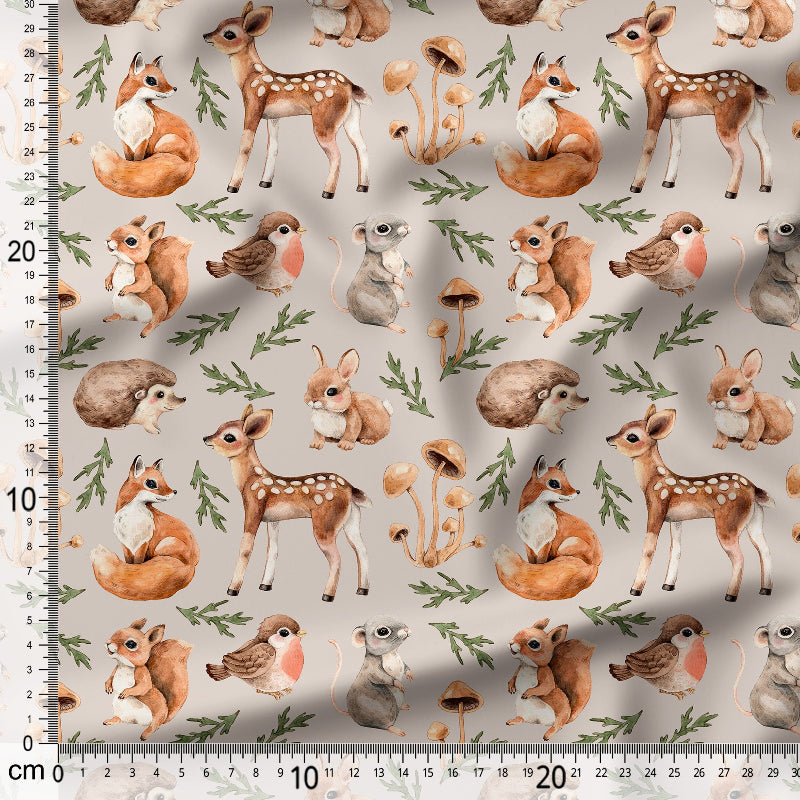Fabric with forest animal pattern including deer, foxes, and birds on a beige background.
