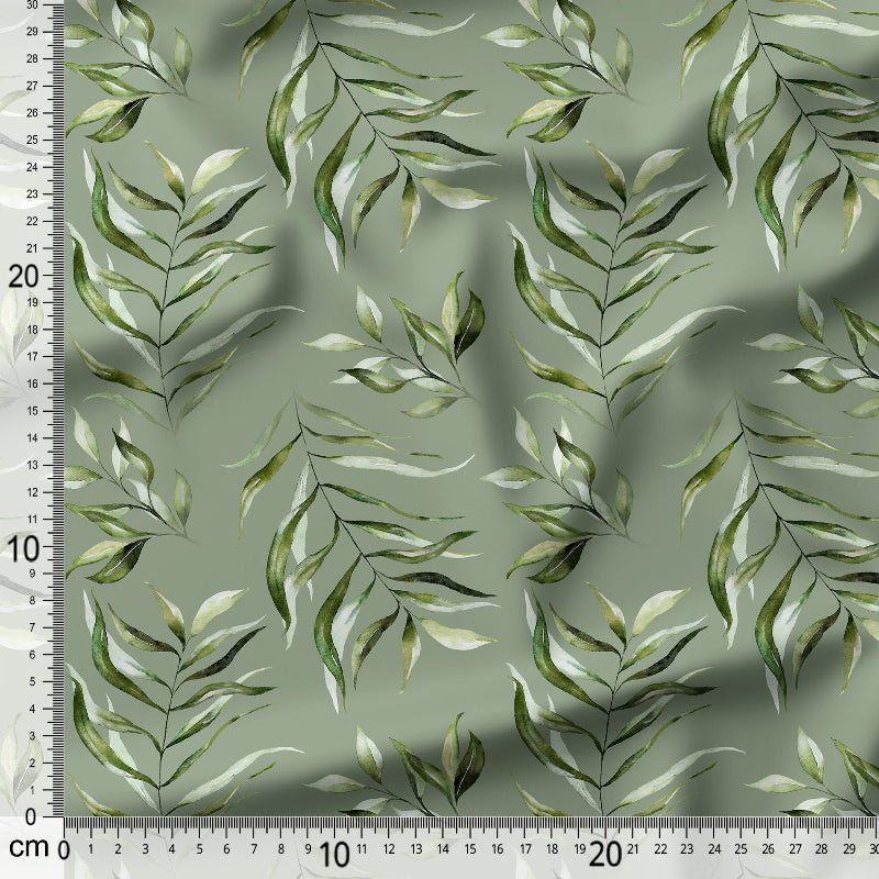 Fabric with green leaf pattern and a ruler for scale on a green background