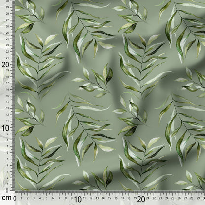 Fabric with green leaf pattern and a ruler for scale on a green background