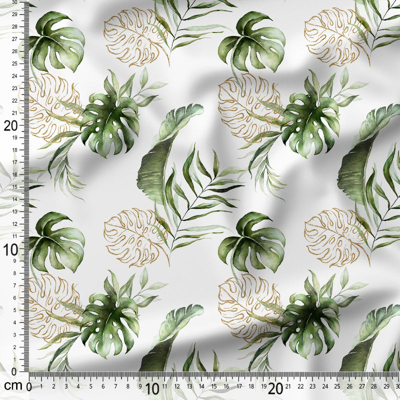 Fabric with green and gold leaf pattern on a white background, measured with a ruler.