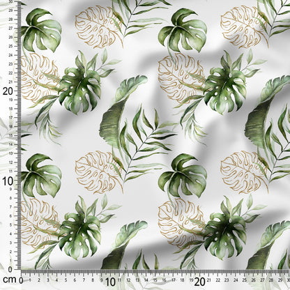 Fabric with green and gold leaf pattern on a white background, measured with a ruler.