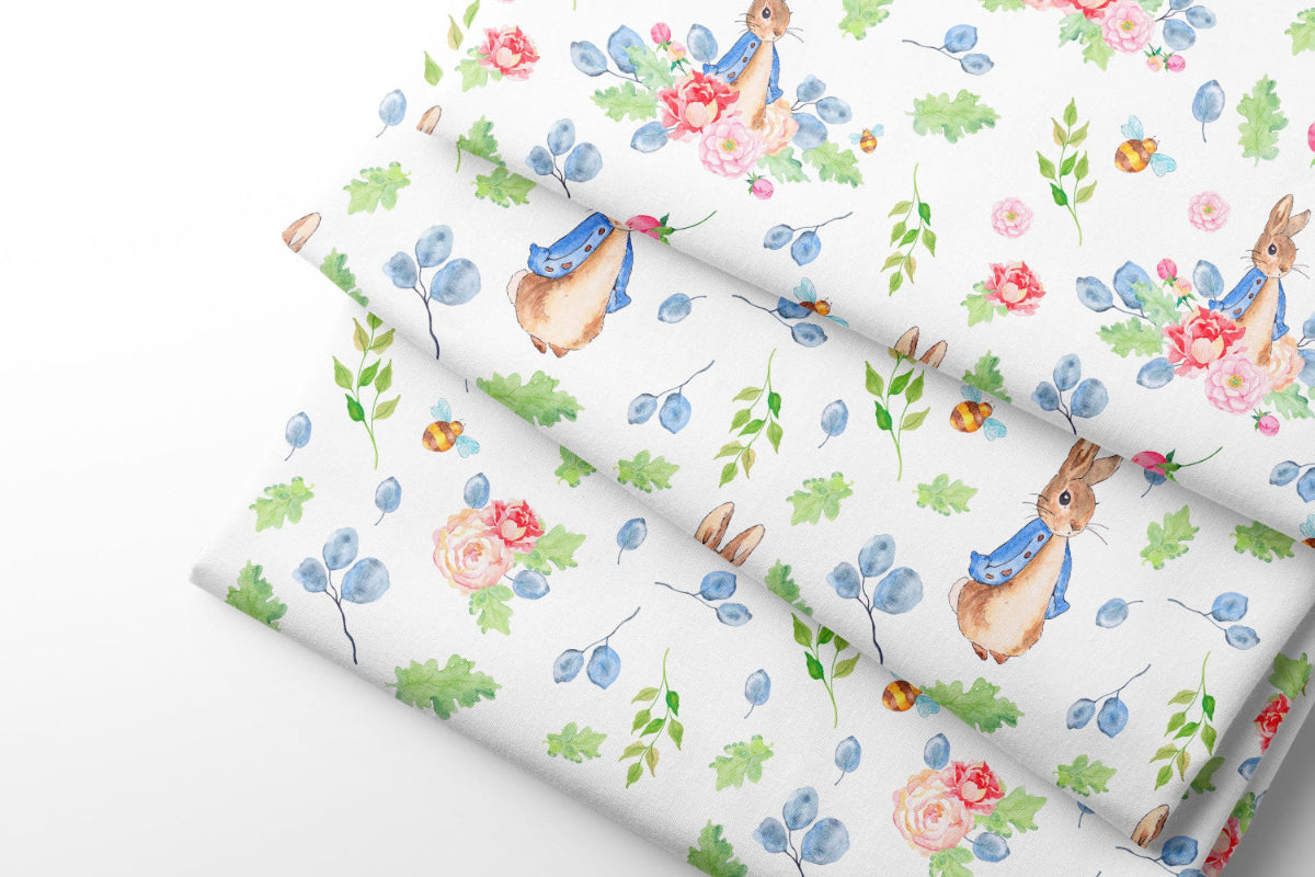 Floral and rabbit patterned coordinating fabric with blue flowers on a white background