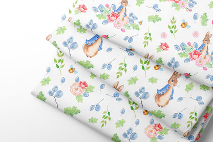 Floral and rabbit patterned coordinating fabric with blue flowers on a white background