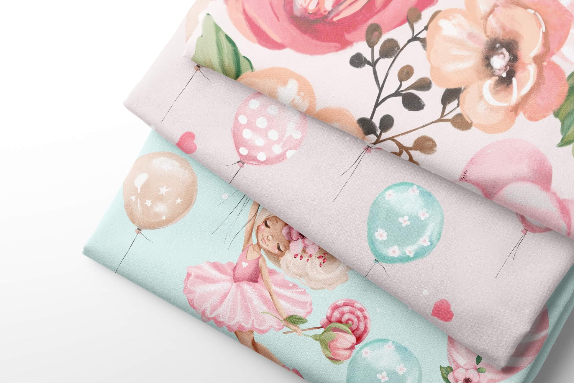 Three sheets of patterned fabric with floral and balloon designs on a white background