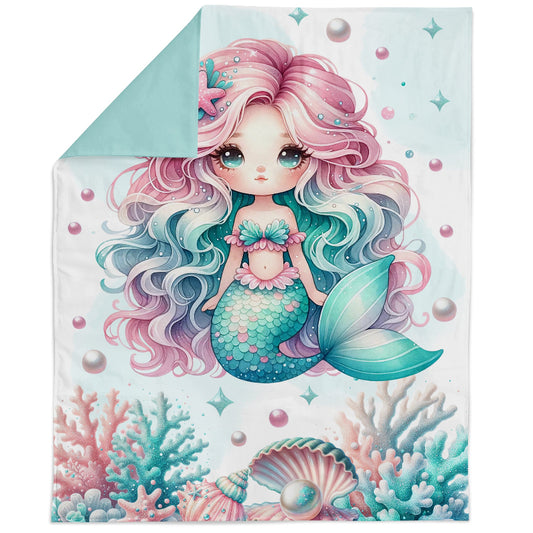 Fabric panel of a mermaid with pink and blue hair on a blanket with coral and shell designs.