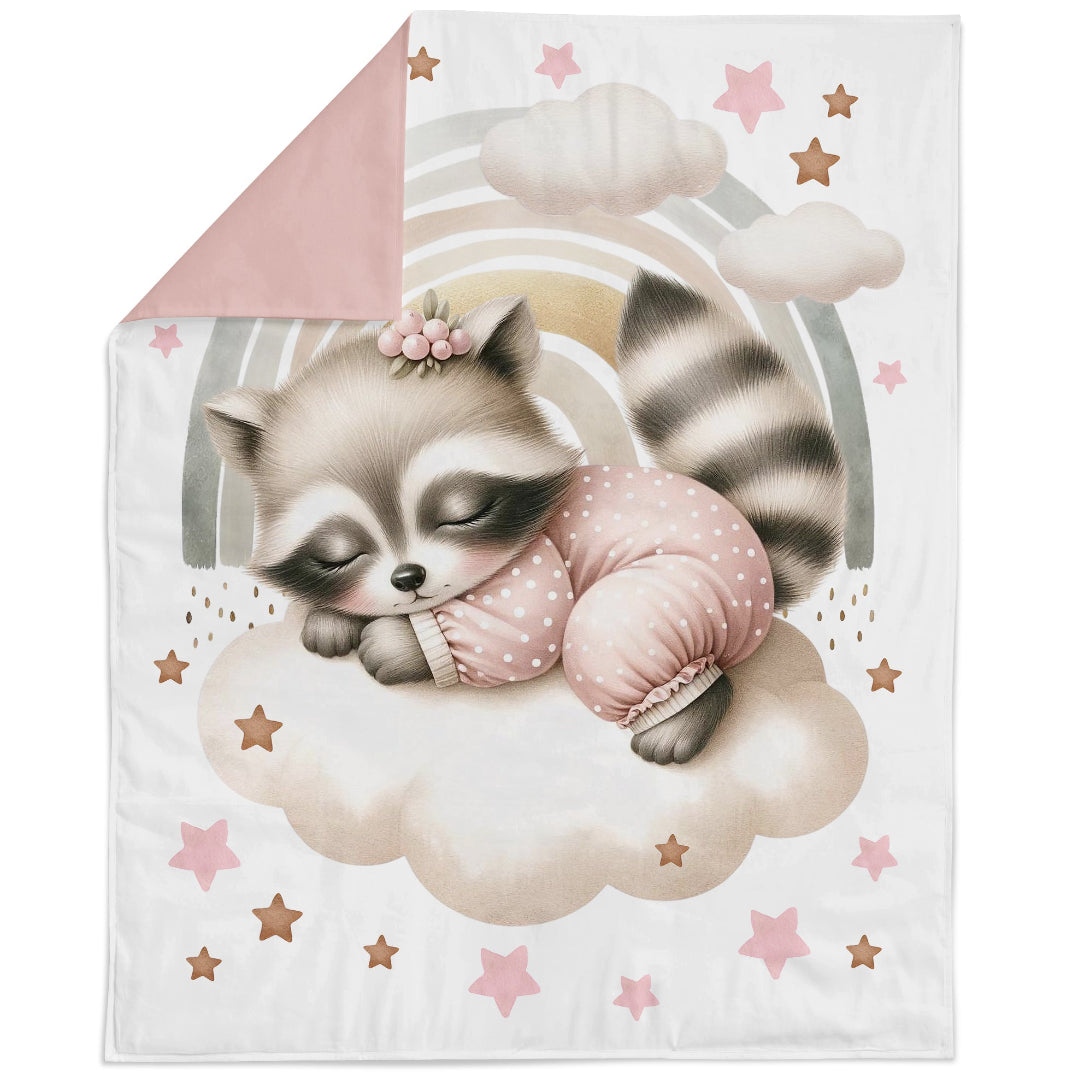 Blanket with a raccoon illustration holding a pink pillow on a cloud, surrounded by stars.