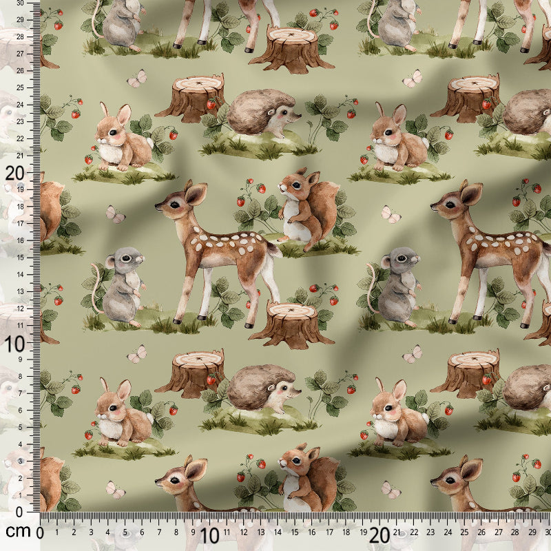 Fabric with forest-themed design featuring deer, rabbits, and hedgehogs on a green background.