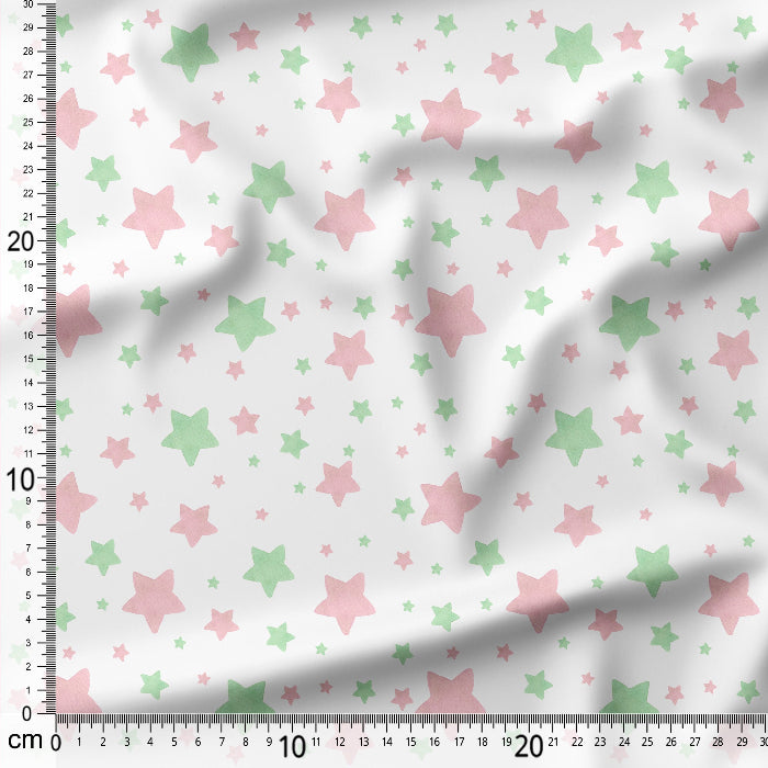 Fabric with pink and green star pattern on a white background, measured with a ruler.