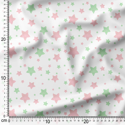 Fabric with pink and green star pattern on a white background, measured with a ruler.