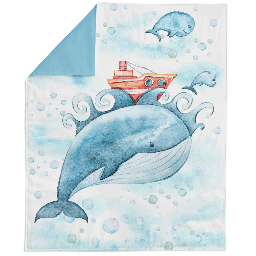 A fabric panel featuring a whale and a boat in a stylized print, indicating it is designed for quilting or crafting projects.