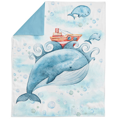 A fabric panel featuring a whale and a boat in a stylized print, indicating it is designed for quilting or crafting projects.