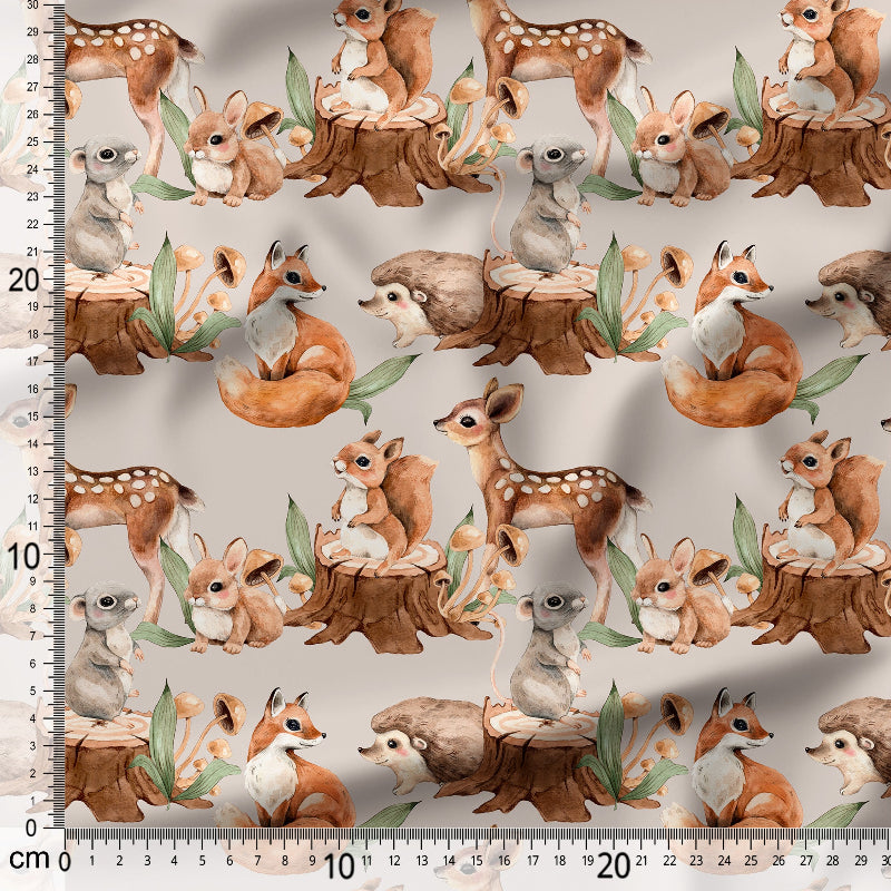 Pattern of forest animals on fabric with a ruler for scale.