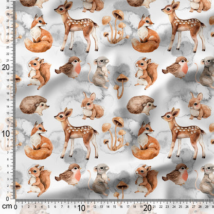 Fabric with forest animal pattern including deer, foxes, rabbits, and birds on a white background with a ruler for scale.