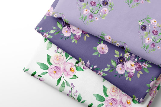 Three fabric sheets of floral-patterned paper in purple, white, and a mix of both.