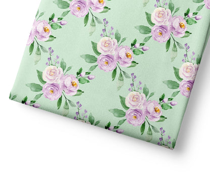 Floral patterned fabric with purple flowers on a light green background