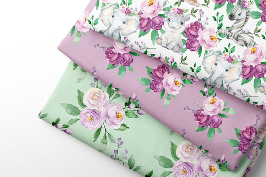 Three rolls of floral-patterned fabric with unicorns and flowers on a white background.