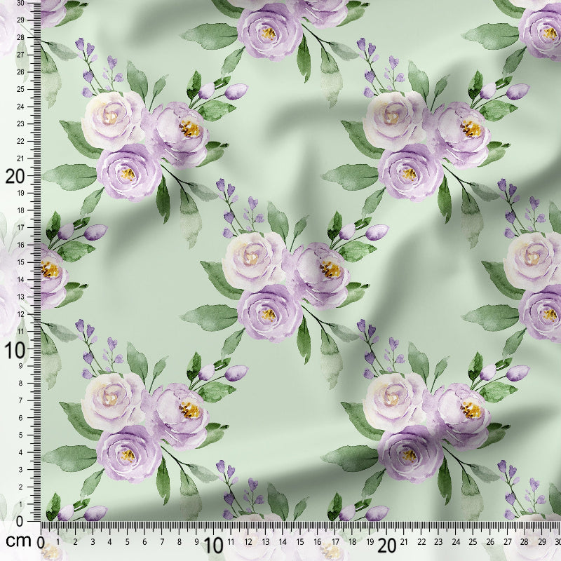 Floral patterned fabric with purple flowers and green leaves on a light green background, with a ruler for scale.