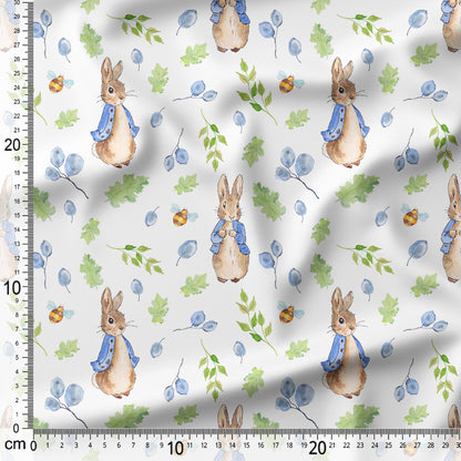 Fabric with cartoon bunnies and leaves pattern on a white background, measured with a ruler.