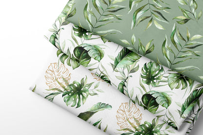 Three rolls of fabric with green leaf patterns on a light gray background