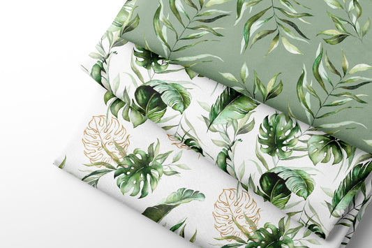Three rolls of fabric with green leaf patterns on a light gray background