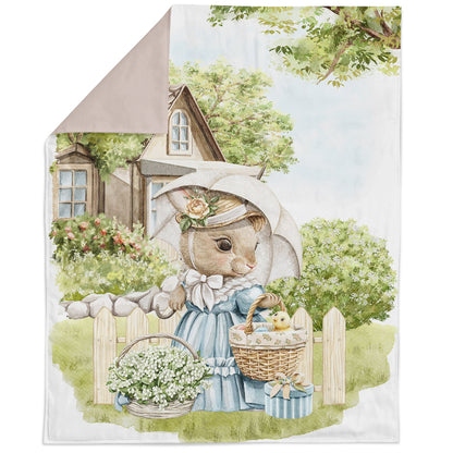 A fabric panel featuring an illustration of an Easter rabbit family, with the rabbit holding a basket of flowers, set against a rural house and tree background.