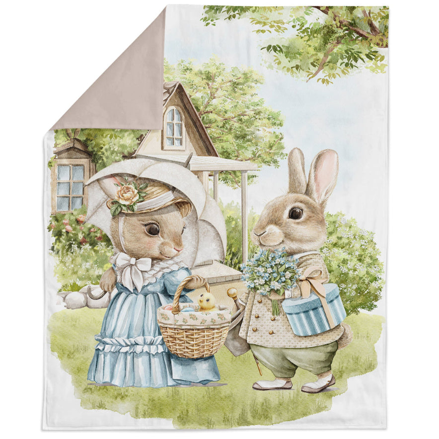 A fabric panel featuring an illustration of two rabbits, one holding a basket of food, the other with a parasol, in a pastoral setting with a house and trees in the background.