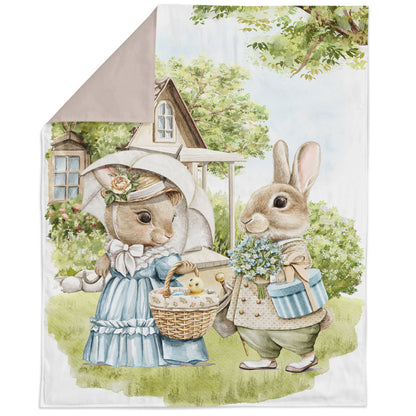 A fabric panel featuring an illustration of two rabbits, one holding a basket of food, the other with a parasol, in a pastoral setting with a house and trees in the background.