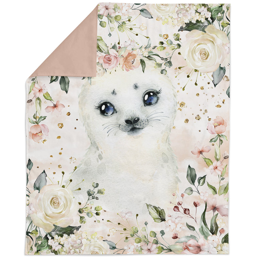 A fabric panel featuring a printed design with a cute animal (seal) in the center surrounded by a floral pattern with various colors and gold accents.